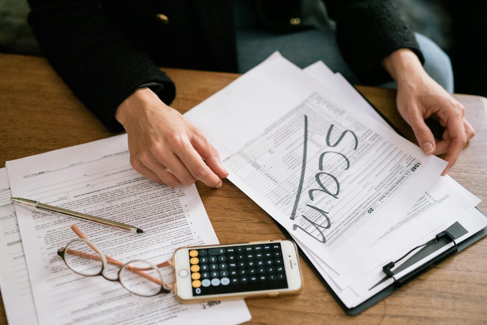 Mesa de trabalho com calculadora e documentos fiscais